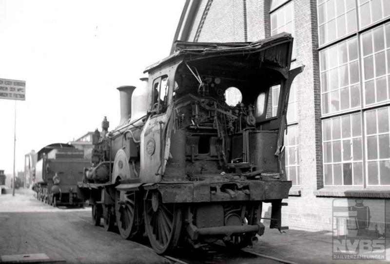 Op het terrein van de centrale werkplaats Tilburg (Wpc) zien we stoomlocomotief 1611, die hier is terechtgekomen na een ongeval in Zutphen. De tender is reeds verwijderd. De Schotse 2B-locomotieven serie 1600 van fabrikant Sharp Stewart, het latere North British, waren op 7 april 1939, toen deze foto werd gemaakt, al niet jong meer: de 1611 dateert van 1891 (H.G.Hesselink; 571.187D).